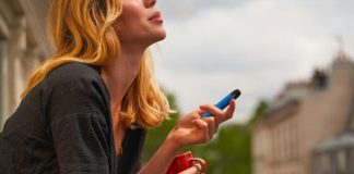 a woman holding a cup and a cell phone