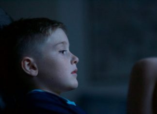 boy leaning on black wall