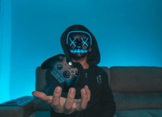 person sitting on chair while holding Xbox One controller