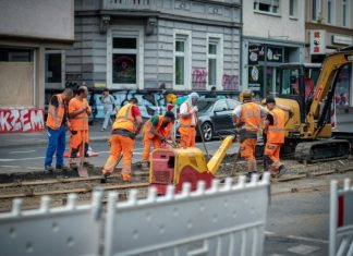 group of men in orange suit standing near building during daytime