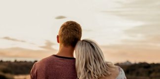 man and woman standing on brown field during daytime