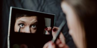 woman holding black framed mirror