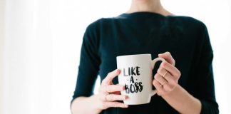 woman holding white mug while standing