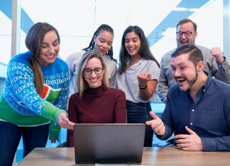 ‘Refer a Friend’ Done Right: Proven Strategies for Success men and women sitting and standing while staring at laptop