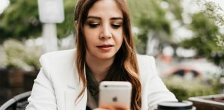 woman in white blazer holding white samsung android smartphone