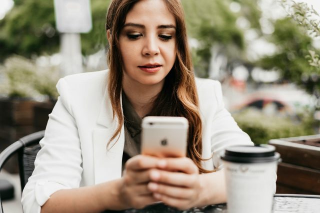 Photo by BRUNO CERVERA woman in white blazer holding white samsung android smartphone