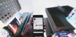 high angle photo of person holding turned on smartphone with tall buildings background