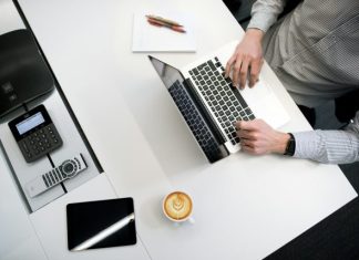 How Payroll Software Can Streamline Travel Agency Operations person using laptop on white wooden table