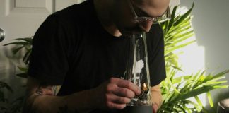 a man with a tattoo on his arm holding a glass