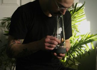 Key Features That Make Some Bongs Superior a man with a tattoo on his arm holding a glass