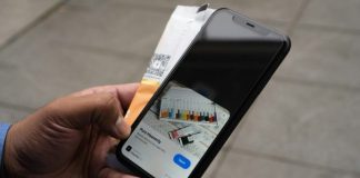 a person holding an iphone with a credit card in their hand