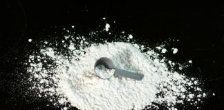 a scoop of powder next to a scoop of sugar