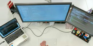 person using macbook pro on white table