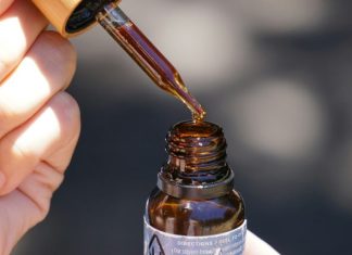 person holding brown glass bottle