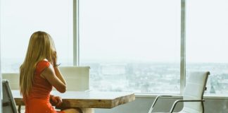 woman talking through mobile phone while sitting on swivel armchair