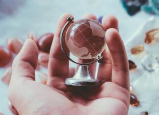 How EOR Services and Technology Are Transforming Global Hiring person holding gray metal framed desk globe paper weight