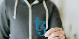 a man in a black hoodie is holding a blue sticker