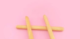 four brown wooden sticks on pink surface