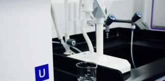 clear glass mug beside white and blue electric toothbrush