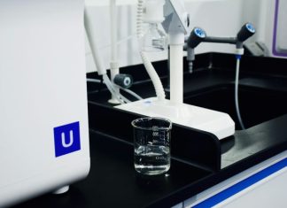 clear glass mug beside white and blue electric toothbrush