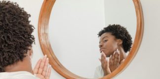 man wearing white shirt facing on wall mirror