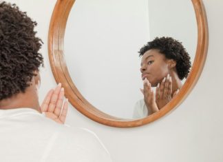 Copper Peptides Might Be Your Skin’s New Best Friend man wearing white shirt facing on wall mirror