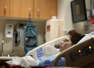 boy lying on beige recliner hospital bed