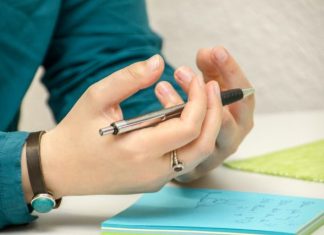 a person sitting at a table using a cell phone