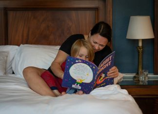 The Hidden Power of Storytime for Toddlers girl in red shirt lying on bed reading book