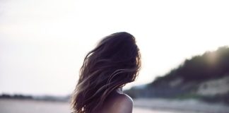 woman standing wearing white bra in selective focus photography