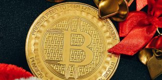 a golden bitcoin sitting on top of a black table
