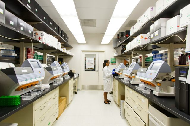 Photo by National Cancer Institute woman standing in front of the digital machine