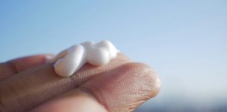 A hand holding a small piece of marshmallow