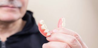 person in black hoodie holding white candy