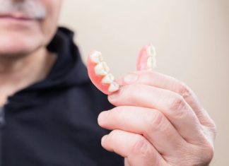 Top Benefits of Visiting an Orthodontist in North Vancouver person in black hoodie holding white candy