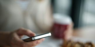 selective focus photography of person holding gray phone
