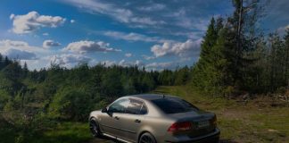 silver bmw coupe parked on dirt road near green trees under blue sky and white clouds