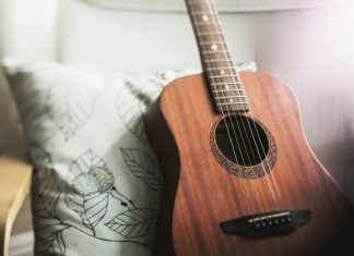The History and Legacy of Martin Guitars in Music selective focus photo of brown guitar on white pillow
