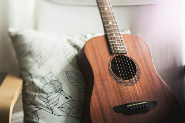 Photo by Kari Shea selective focus photo of brown guitar on white pillow