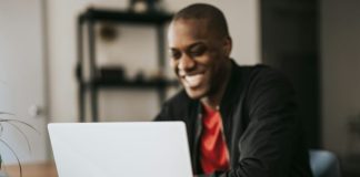 man in black blazer sitting by the table with laptop