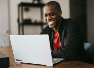 DatingRise Review: Is This a Good Dating Website? man in black blazer sitting by the table with laptop