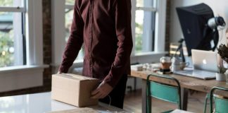 person holding cardboard box on table