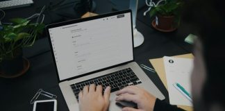 A person sitting at a desk using a laptop computer