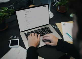 A person sitting at a desk using a laptop computer