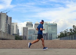 Why Low Energy Might Have Nothing to Do With Age A man running in a city with tall buildings in the background