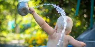 child lifting water dipper