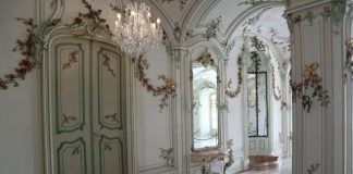 A hallway with a chandelier and a marble floor