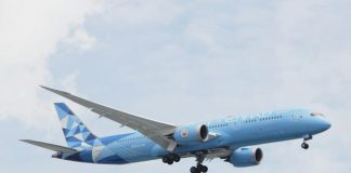 a blue and white airplane flying in the sky