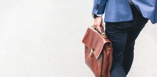 a person holding a brown purse