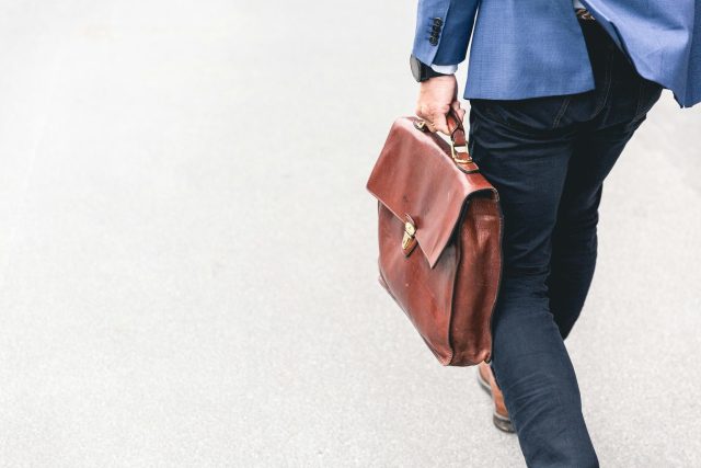 a-person-holding-a-brown-purse a person holding a brown purse